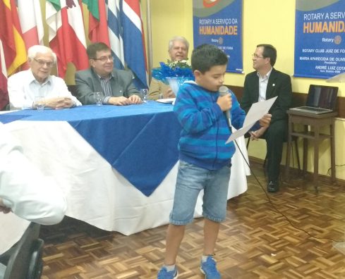 Felipe lê mensagem para os pais no Rotary Norte